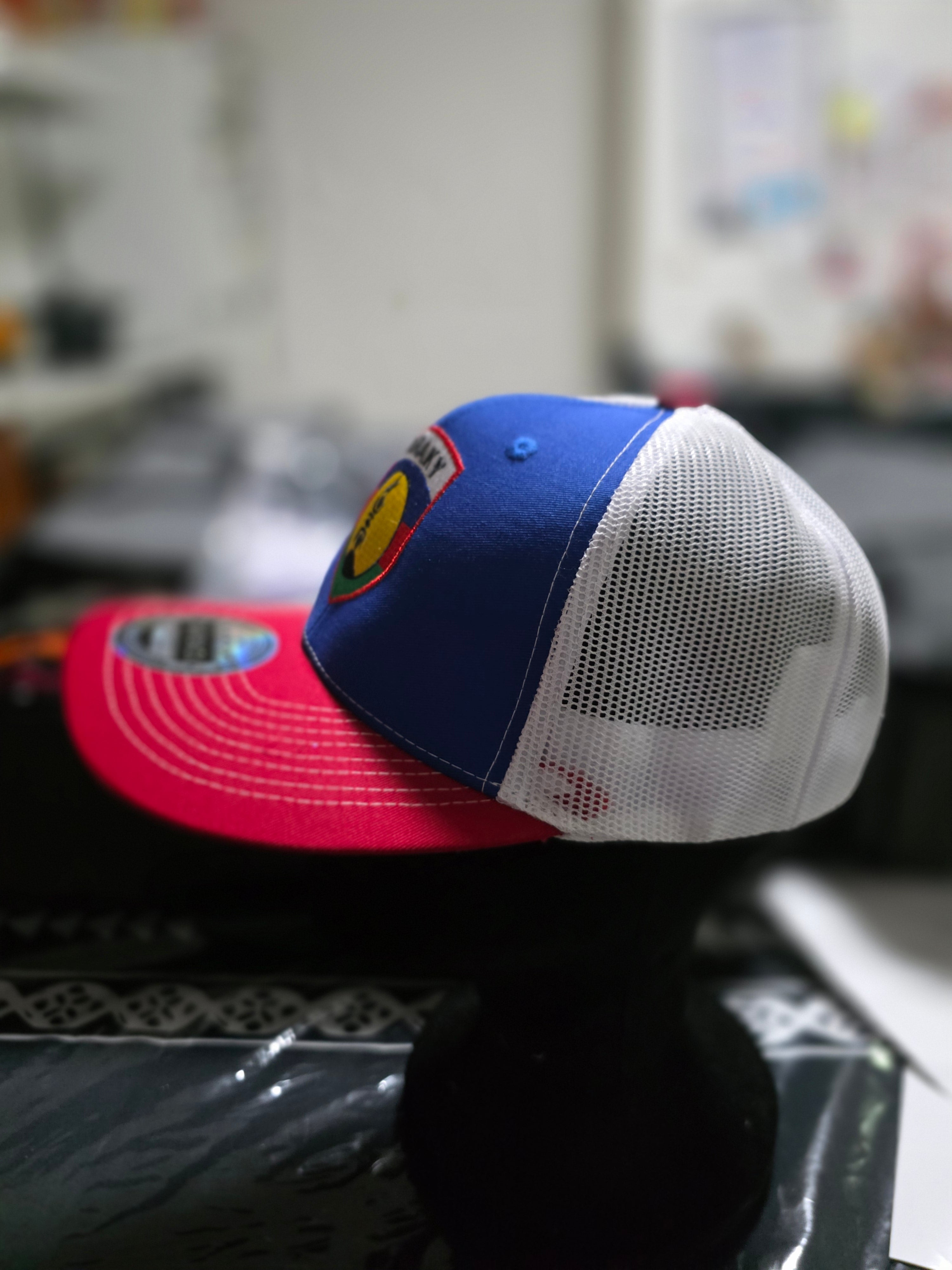 Casquette trucker bleu et rouge avec filet blanc motif Kanaky.